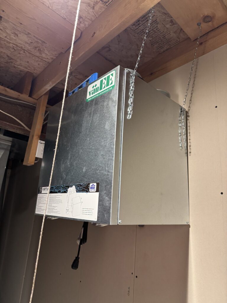 Technician drilling a precise hole for duct installation